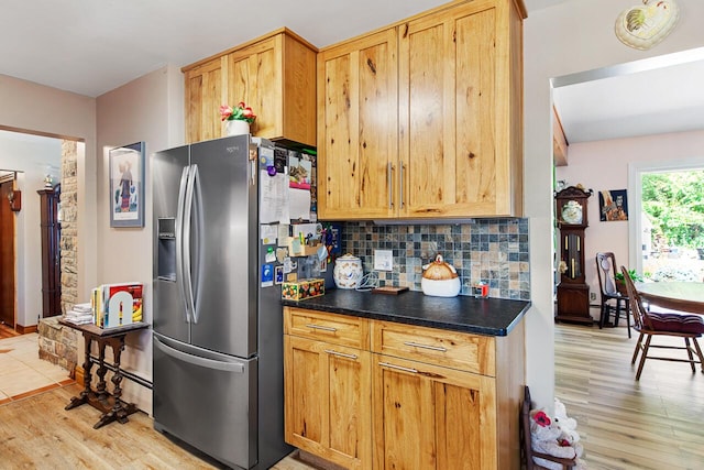 916 Hillcrest Dr, Adrian, MI 49221 - kitchen featuring stainless steel fridge with ice dispenser, light wood-style flooring, tasteful backsplash, and dark countertops