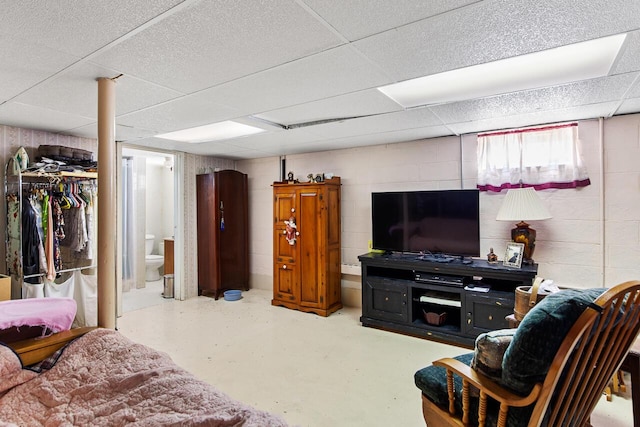 916 Hillcrest Dr, Adrian, MI 49221 - living area featuring concrete flooring, a drop ceiling, and concrete block wall