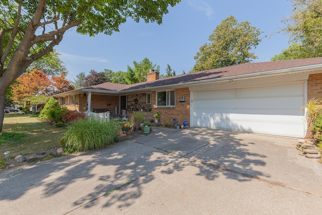 916 Hillcrest Dr, Adrian, MI 49221 - ranch-style home featuring brick siding, a chimney, concrete driveway, and a garage