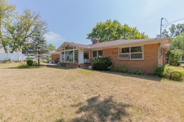 916 Hillcrest Dr, Adrian, MI 49221 - ranch-style home featuring a chimney, brick siding, cooling unit, and a sunroom
