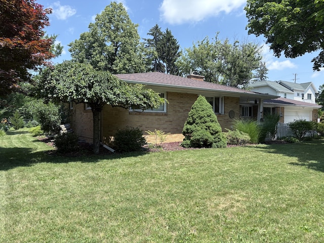 916 Hillcrest Dr, Adrian, MI 49221 - view of front of property with a front yard, brick siding, and a garage