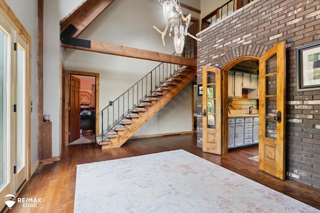 3078 Green Corners Rd, Lapeer, MI 48446 - foyer entrance featuring a towering ceiling, hardwood / wood-style floors, stairs, brick wall, and beamed ceiling