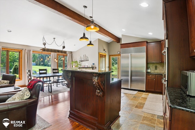 3078 Green Corners Rd, Lapeer, MI 48446 - kitchen featuring stainless steel appliances, backsplash, dark stone counters, hanging light fixtures, and a kitchen bar