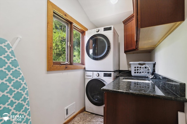 3078 Green Corners Rd, Lapeer, MI 48446 - laundry area featuring estacked washer and dryer and cabinet space