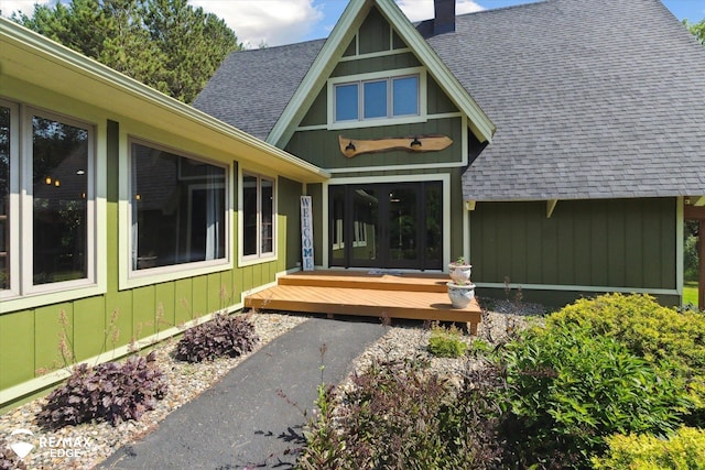 3078 Green Corners Rd, Lapeer, MI 48446 - view of exterior entry with roof with shingles, a chimney, french doors, and a wooden deck