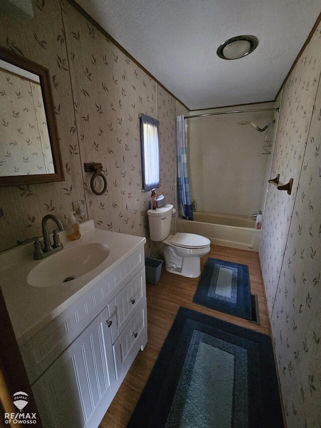 2789 Grass Lake Ave, Clare, MI 48632 - full bath with wood finished floors, wallpapered walls, vanity, shower / bath combo with shower curtain, and crown molding