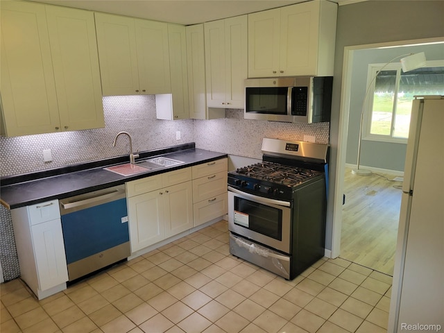 112 Darragh Dr, Battle Creek, MI 49015 - kitchen with appliances with stainless steel finishes, dark countertops, white cabinets, and tasteful backsplash