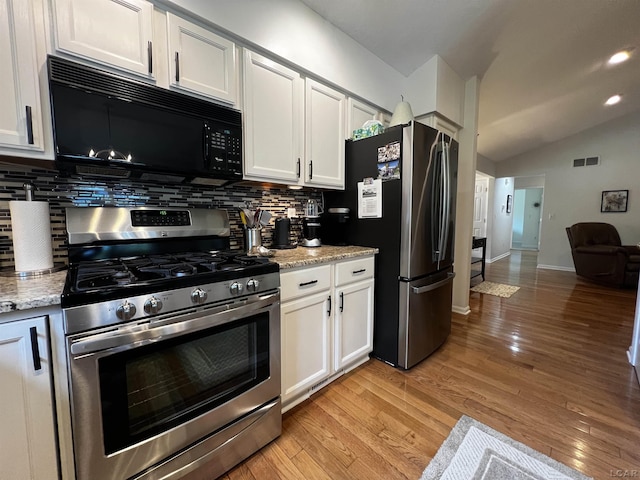 3118 Birch Run, Adrian, MI 49221 - kitchen featuring appliances with stainless steel finishes, decorative backsplash, white cabinets, and lofted ceiling