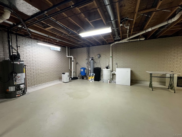 3118 Birch Run, Adrian, MI 49221 - unfinished below grade area with water heater, refrigerator, brick wall, and a water pressure tank