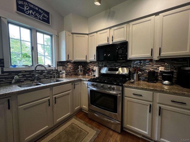 3118 Birch Run, Adrian, MI 49221 - kitchen with black microwave, stainless steel range with gas stovetop, decorative backsplash, dark wood-style flooring, and stone countertops