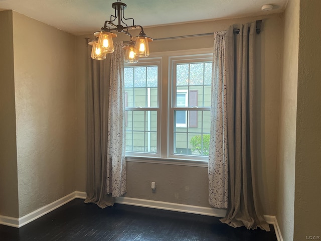 1370 University Ave, Adrian, MI 49221 - unfurnished room featuring plenty of natural light, dark wood-style flooring, a chandelier, a smoke detector, and a textured wall
