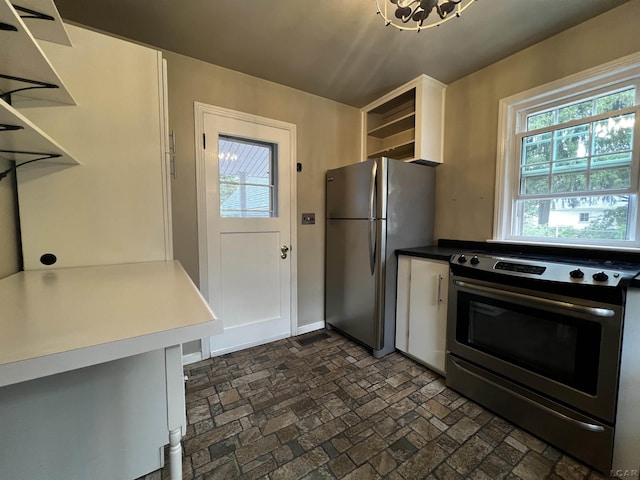 1370 University Ave, Adrian, MI 49221 - kitchen with stainless steel appliances, open shelves, brick patterned floors, and white cabinetry
