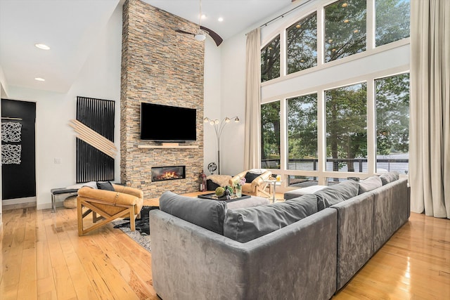 15518 Oak Ridge Dr, Spring Lake, MI 49456 - living room featuring high vaulted ceiling, light wood finished floors, and a stone fireplace