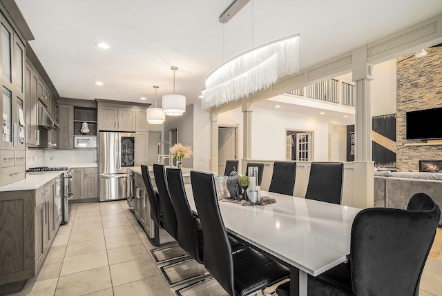 15518 Oak Ridge Dr, Spring Lake, MI 49456 - dining space with light tile patterned floors, recessed lighting, and a stone fireplace