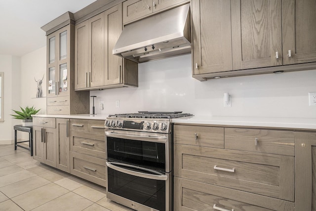 15518 Oak Ridge Dr, Spring Lake, MI 49456 - kitchen with range with two ovens, under cabinet range hood, light tile patterned floors, and light countertops