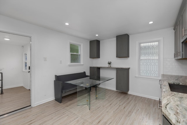 21560 Poinciana St, Southfield, MI 48033 - kitchen with light wood finished floors, healthy amount of natural light, light stone counters, recessed lighting, and gray cabinetry
