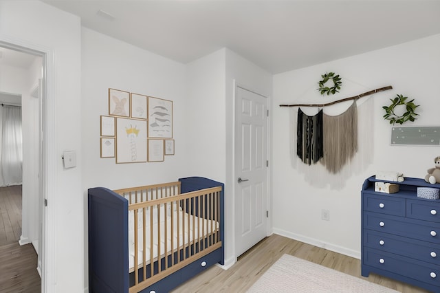 21560 Poinciana St, Southfield, MI 48033 - bedroom with wood finished floors and a crib