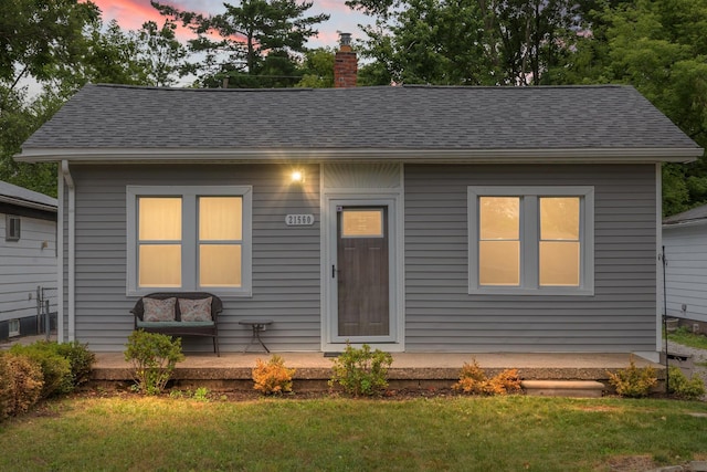 21560 Poinciana St, Southfield, MI 48033 - bungalow-style house featuring a chimney, roof with shingles, and a yard