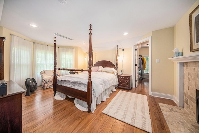 14300 Ridgemont St, Gregory, MI 48137 - bedroom featuring a fireplace with flush hearth and light wood-style flooring