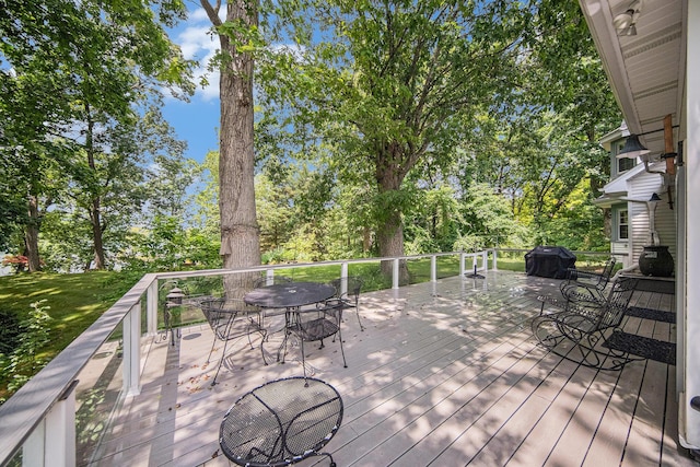 14300 Ridgemont St, Gregory, MI 48137 - wooden deck with outdoor dining space, area for grilling, and view of scattered trees