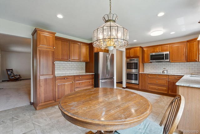 1726 Black Maple Dr, Rochester Hills, MI 48309 - kitchen featuring appliances with stainless steel finishes, brown cabinets, backsplash, hanging light fixtures, and recessed lighting
