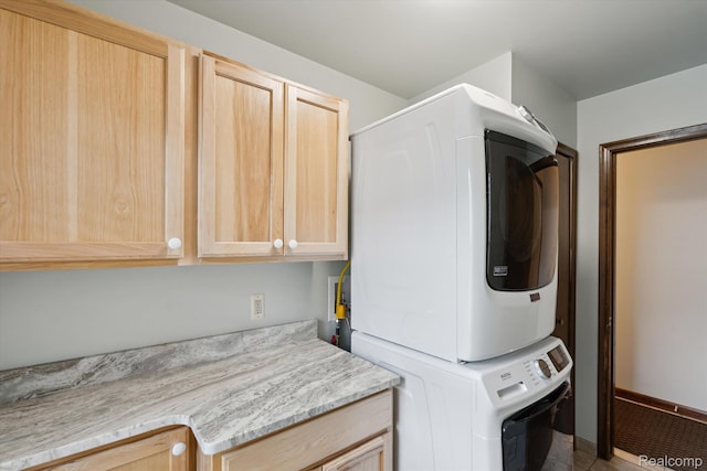 1726 Black Maple Dr, Rochester Hills, MI 48309 - laundry area featuring stacked washer / dryer, cabinet space, and tile patterned flooring