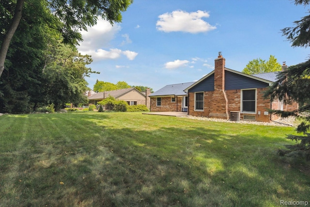 1726 Black Maple Dr, Rochester Hills, MI 48309 - back of property featuring a yard, a patio area, a chimney, and brick siding