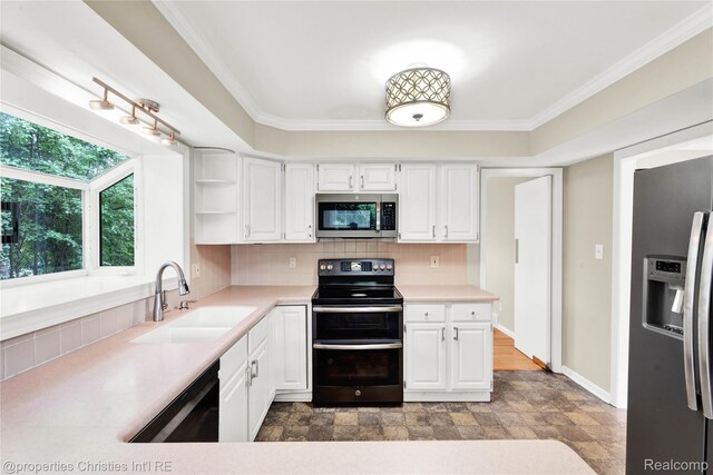 4770 Hedgewood Dr, Bloomfield Hills, MI 48301 - kitchen with stainless steel appliances, white cabinetry, light countertops, stone finish floors, and ornamental molding