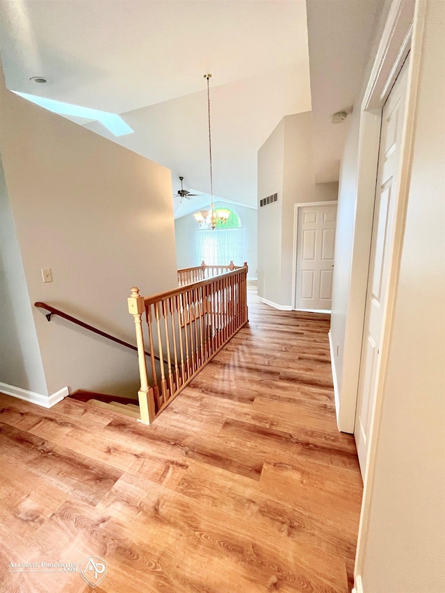 9330 Pinecrest Ct, Davison, MI 48423 - hall with an upstairs landing, wood finished floors, lofted ceiling, a skylight, and a chandelier