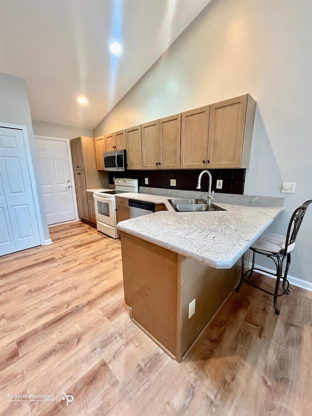 9330 Pinecrest Ct, Davison, MI 48423 - kitchen with white range with electric stovetop, stainless steel microwave, a peninsula, light wood-type flooring, and high vaulted ceiling