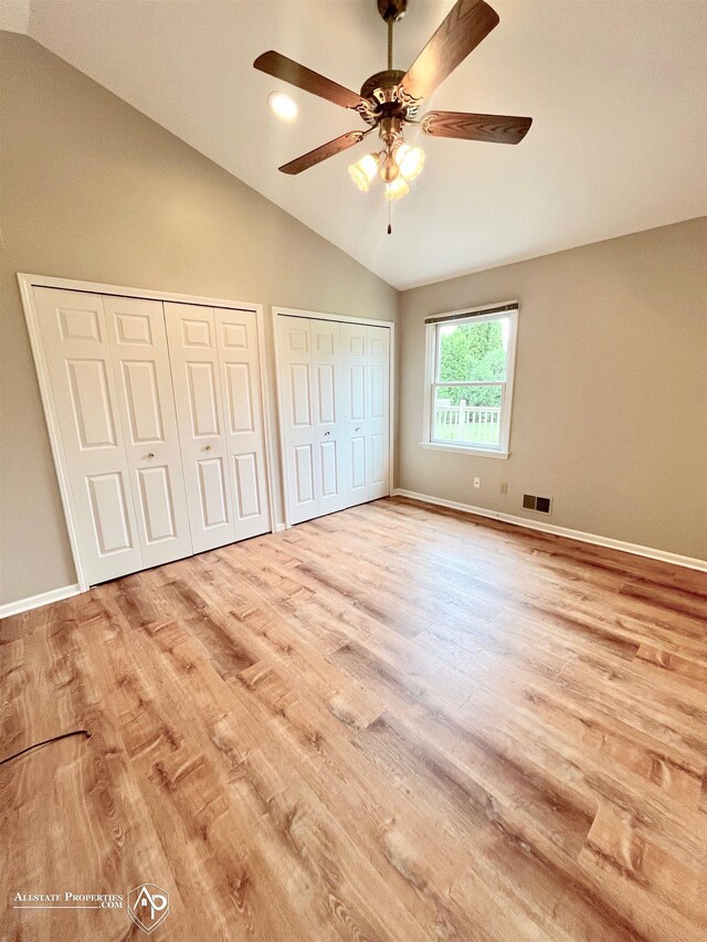 9330 Pinecrest Ct, Davison, MI 48423 - unfurnished bedroom featuring lofted ceiling, two closets, wood finished floors, and ceiling fan