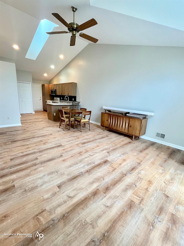 9330 Pinecrest Ct, Davison, MI 48423 - dining area with ceiling fan, a skylight, light wood-style flooring, vaulted ceiling, and recessed lighting