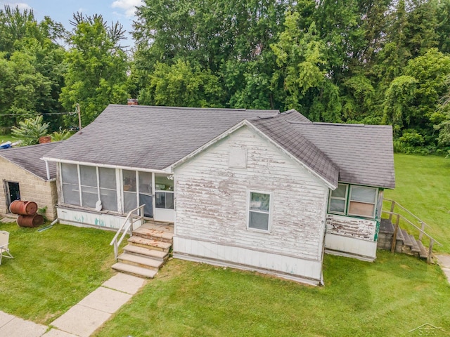 120 S Miami St, Saint Charles, MI 48655 - view of front facade with a sunroom, roof with shingles, stairs, stone siding, and a front yard