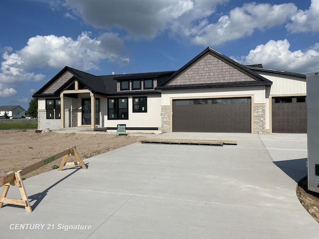 8884 Copper Ct, Freeland, MI 48623 - view of front of house with an attached garage, concrete driveway, and stone siding