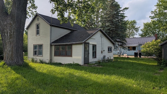 6596 Hillsinger St, Elwell, MI 48832 - view of property exterior featuring a lawn and roof with shingles