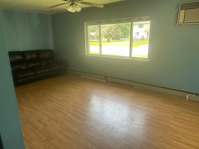 129 W Walnut St, Saint Charles, MI 48655 - unfurnished living room with a ceiling fan, wood finished floors, and a wall unit AC