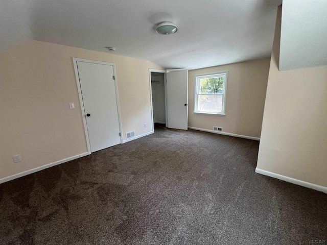 1999 Harold St, Adrian, MI 49221 - unfurnished bedroom featuring vaulted ceiling and dark colored carpet
