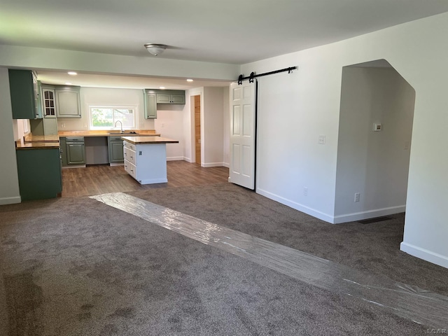 1999 Harold St, Adrian, MI 49221 - kitchen featuring a barn door, dark carpet, glass insert cabinets, and recessed lighting