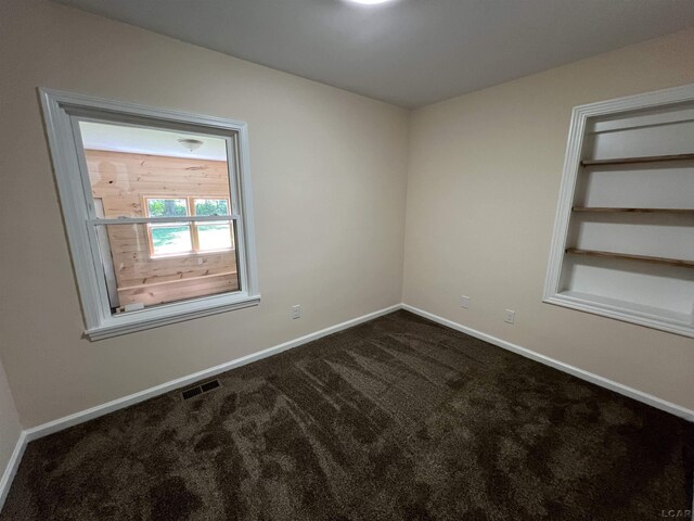 1999 Harold St, Adrian, MI 49221 - empty room with dark carpet and baseboards