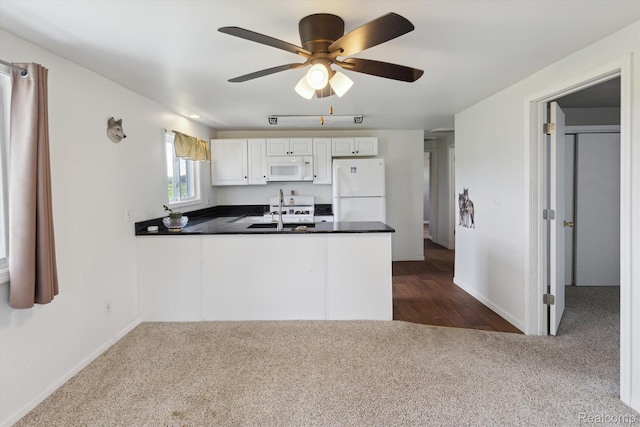 1612 Fischer Dr, Saginaw, MI 48601 - kitchen featuring white appliances, dark colored carpet, a peninsula, dark countertops, and a ceiling fan