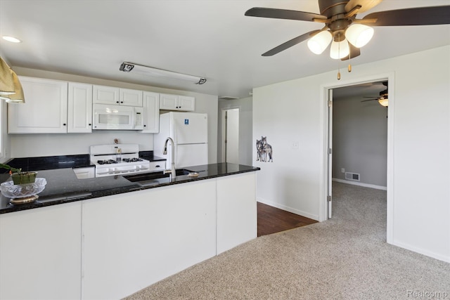 1612 Fischer Dr, Saginaw, MI 48601 - kitchen with white appliances, ceiling fan, a peninsula, dark colored carpet, and white cabinets