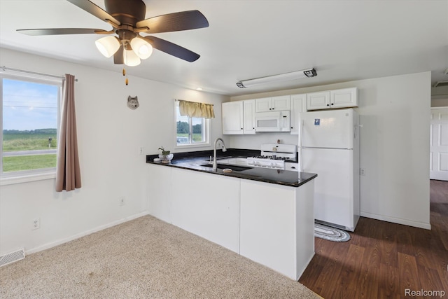 1612 Fischer Dr, Saginaw, MI 48601 - kitchen featuring white appliances, a peninsula, dark countertops, ceiling fan, and white cabinets