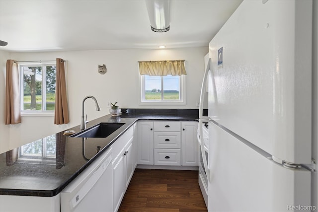 1612 Fischer Dr, Saginaw, MI 48601 - kitchen with white appliances, dark countertops, a peninsula, and white cabinetry