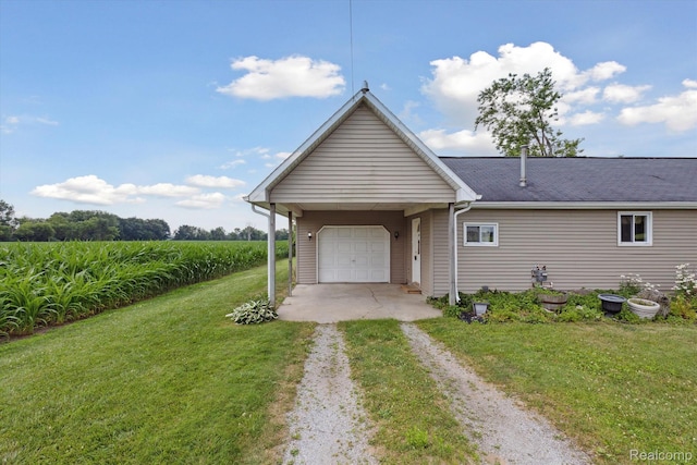 1612 Fischer Dr, Saginaw, MI 48601 - back of property with driveway, a lawn, and a garage