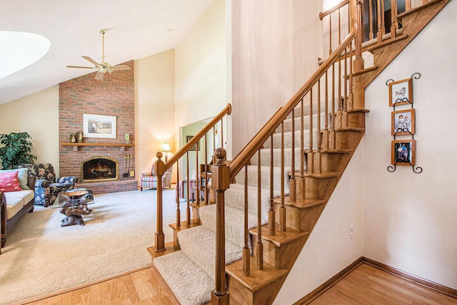 1410 Rothbury Dr NE, Grand Rapids, MI 49505 - staircase with wood finished floors, a ceiling fan, a brick fireplace, and high vaulted ceiling
