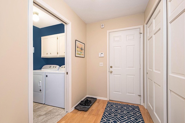1410 Rothbury Dr NE, Grand Rapids, MI 49505 - laundry area featuring light wood-style floors, washing machine and clothes dryer, and cabinet space