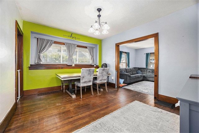 2028 Rowe Ave NE, Grand Rapids, MI 49505 - dining area featuring a chandelier, wood finished floors, plenty of natural light, and a textured ceiling