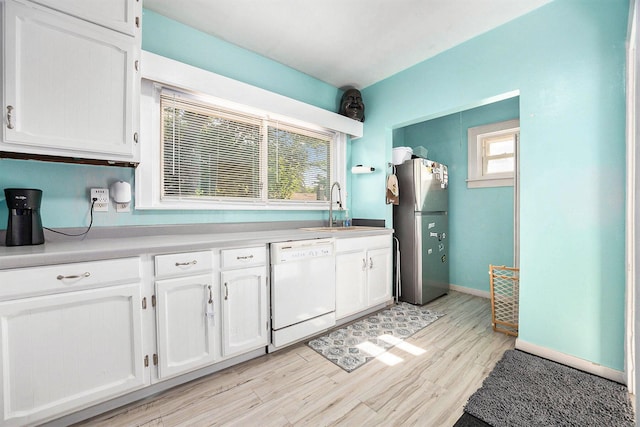 2028 Rowe Ave NE, Grand Rapids, MI 49505 - kitchen featuring freestanding refrigerator, white dishwasher, and white cabinets