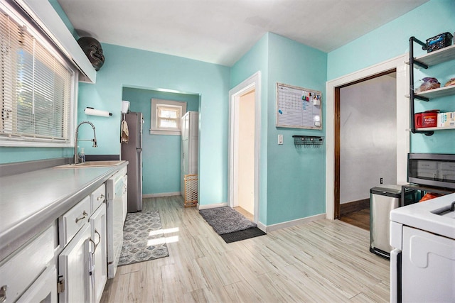 2028 Rowe Ave NE, Grand Rapids, MI 49505 - kitchen with light wood-style floors, white cabinetry, open shelves, stainless steel microwave, and light countertops