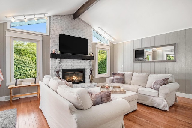 1836 Ridgewood Ave SE, Grand Rapids, MI 49506 - living room featuring rail lighting, hardwood / wood-style flooring, a brick fireplace, plenty of natural light, and wood walls